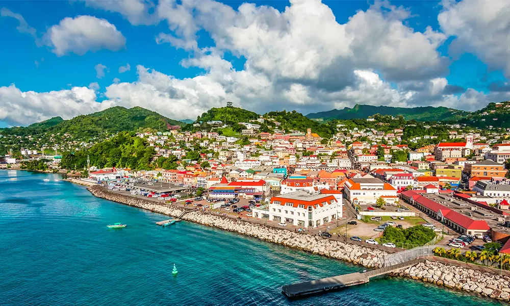 A coastal town on a Caribbean island, with colourful waterfront buildings and green hills behind.